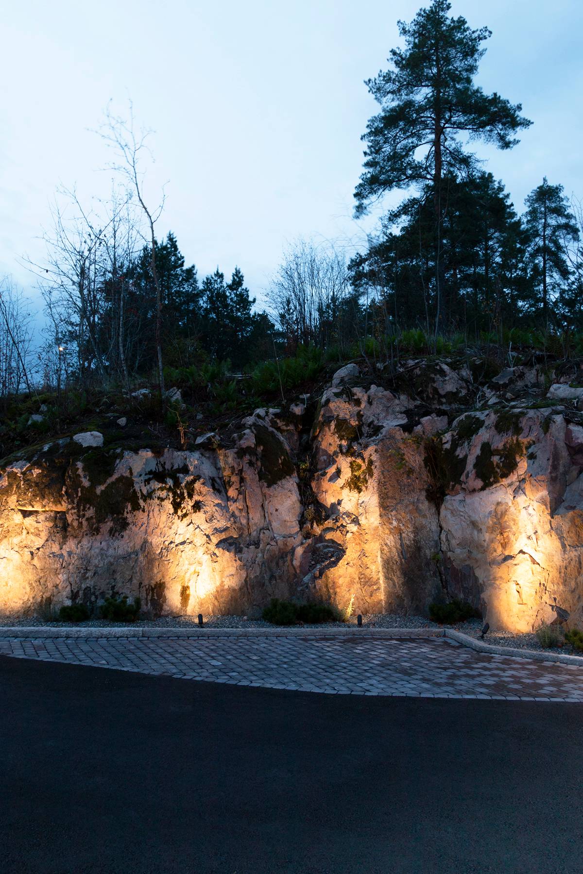 Luminarias led orientadas hacia la pared rocosa.